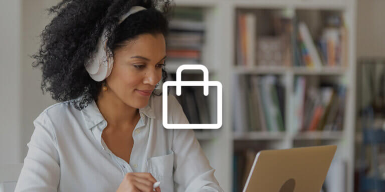 A woman wearing white headphones is looking at a laptop screen.