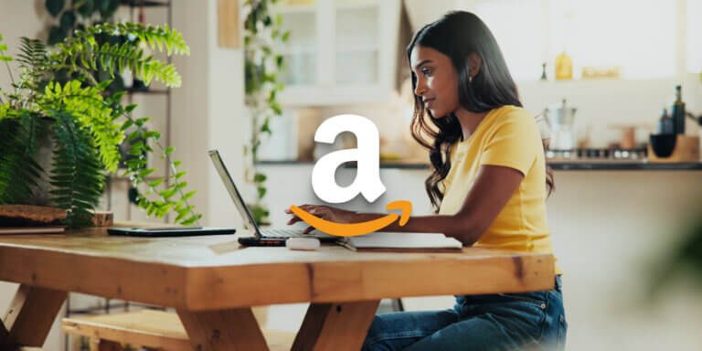 An image showing a girl with long black hair and wearing a yellow shirt using a laptop with an amazon logo in the centre.