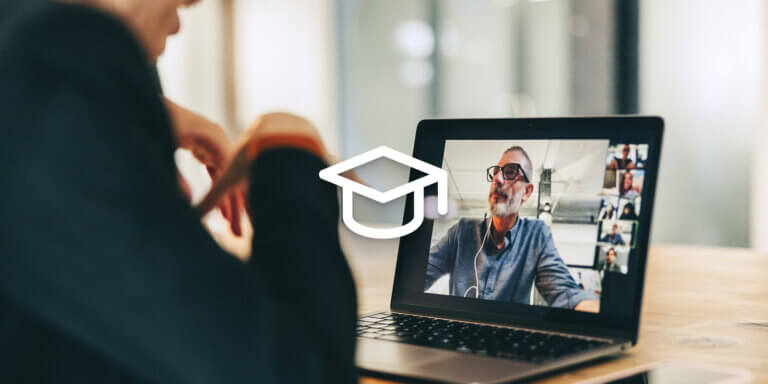 An image showing a man wearing glasses talking to another person via a camera on a laptop screen.