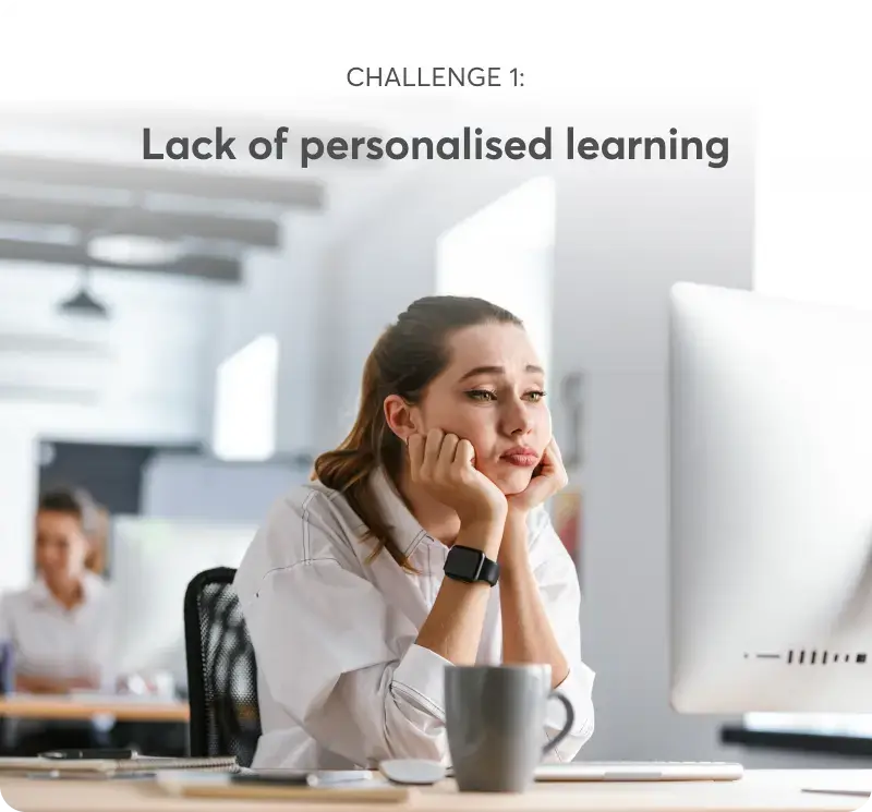 A woman sitting at a desk and looking at a computer screen looking bored.